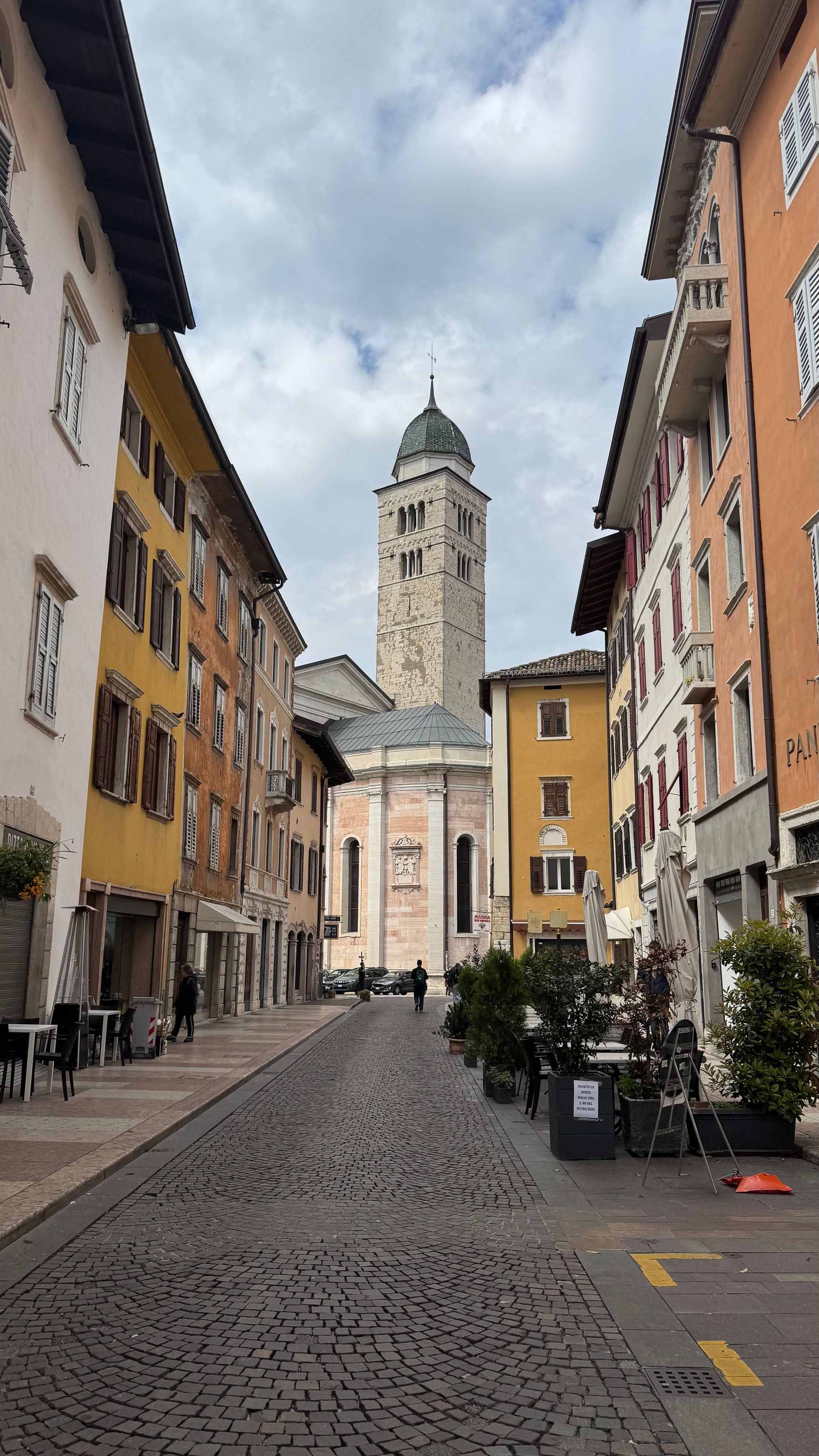 Una via acciottolata del centro storico che si apre sul campanile di una chiesa